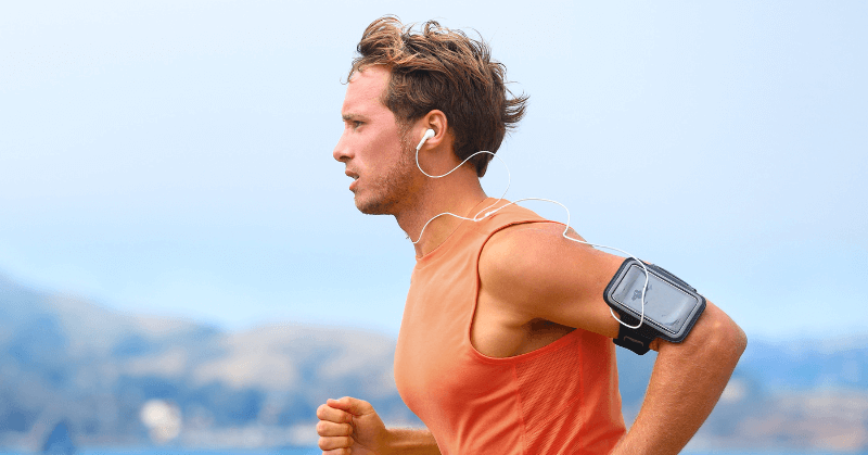 A man listening to music while running outdoors A man listening to music while running outdoors