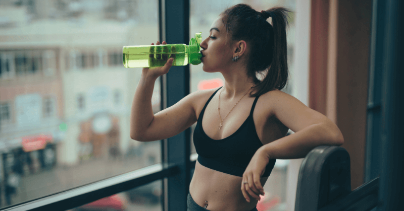 Woman drinking water after a workout Woman drinking water after a workout