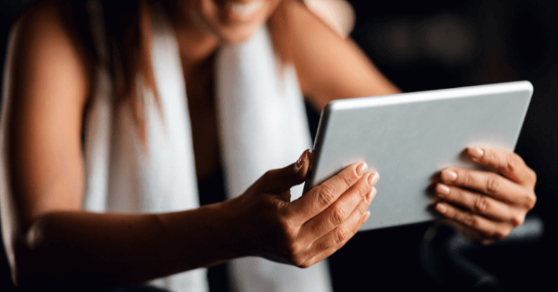 Woman looking at tablet while cycling