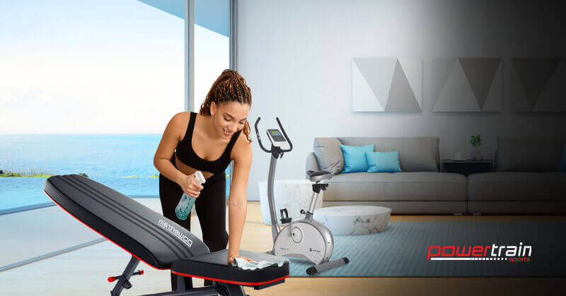 Woman wiping down a gym bench