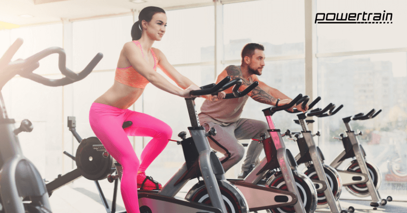Man and woman working out on indoor bikes
